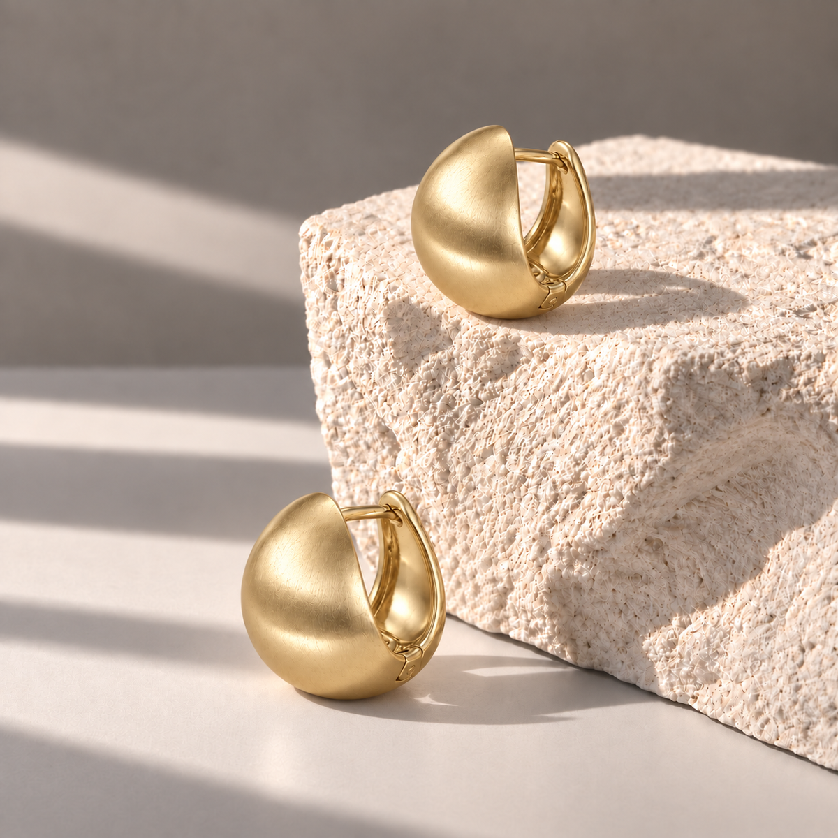 Luna Gold Dome Studs at side angles on pale limestone