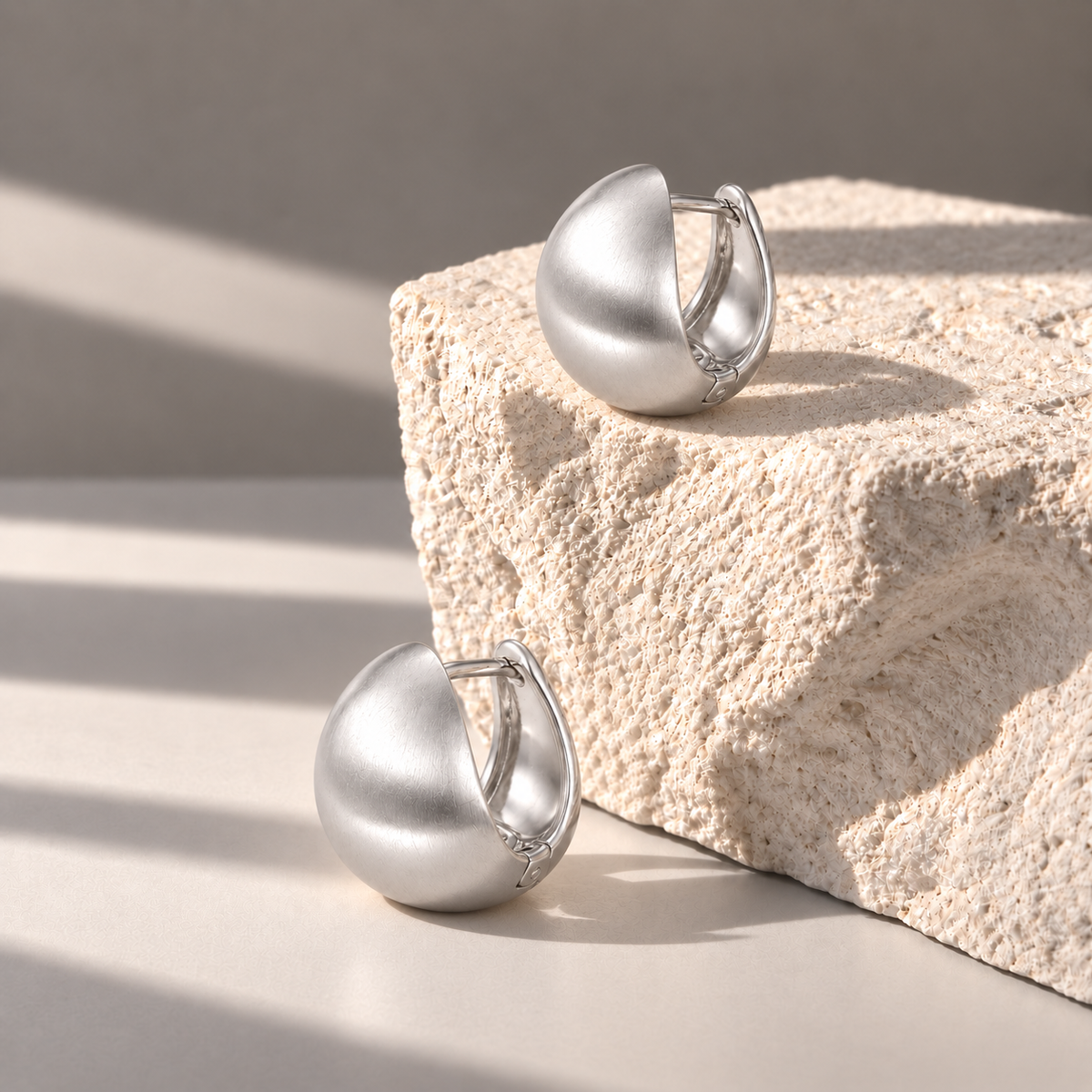 Luna Silver Dome Studs at side angles on pale limestone