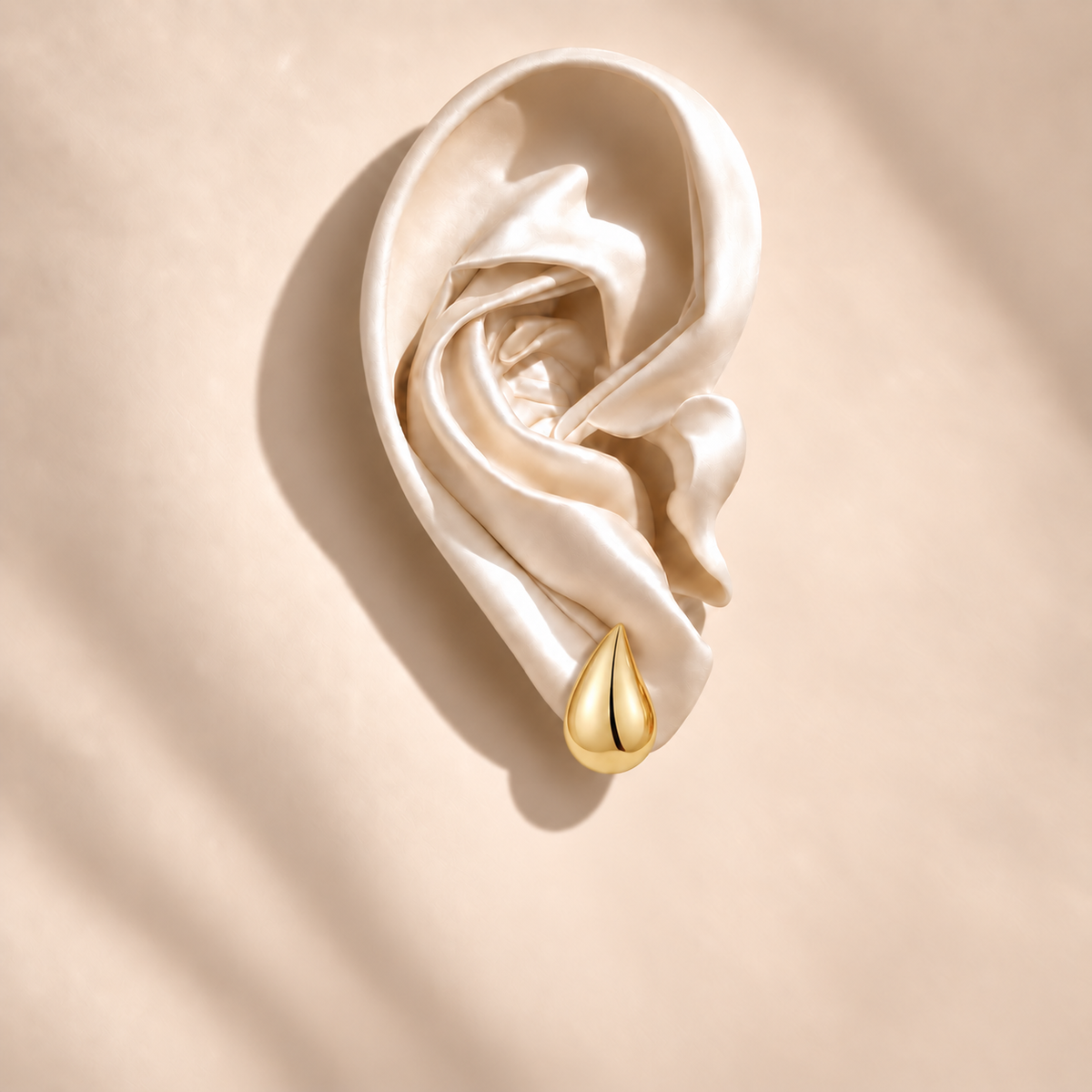 Solène Gold Teardrop Stud on an ivory satin ear