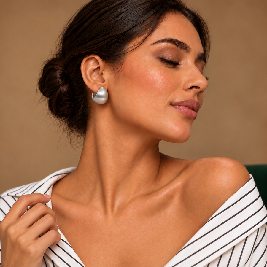 Luna Silver Dome Studs worn with an ivory striped shirt in a warm neutral studio