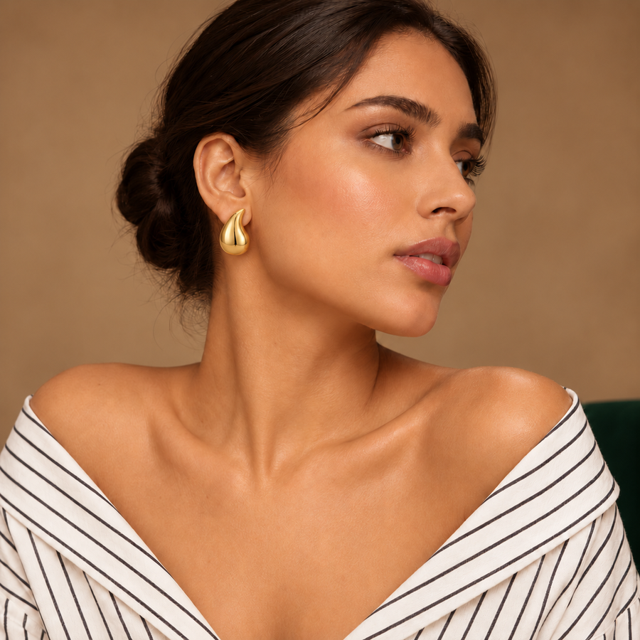 Solène Gold Teardrop Studs worn by a model in an ivory striped shirt